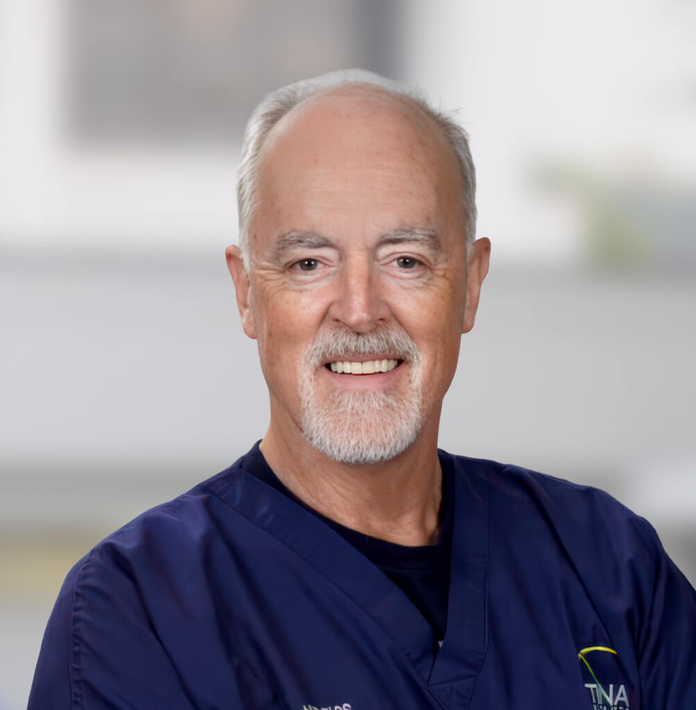 Portrait of David J. Hunt, MD, FACS, retina specialist in blue medical scrubs.