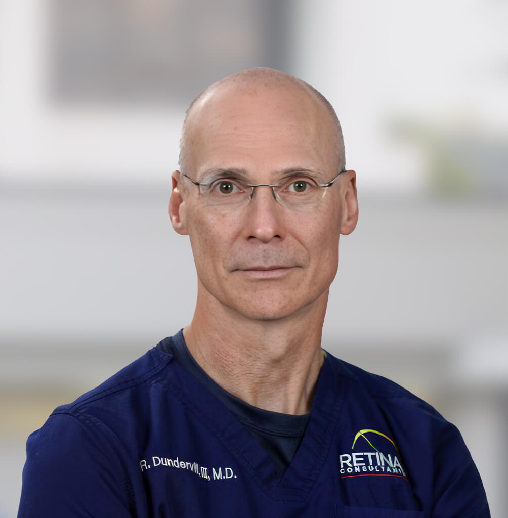 Portrait of Robert F. Dundervill, III, MD, FACS, retina specialist in blue medical scrubs.